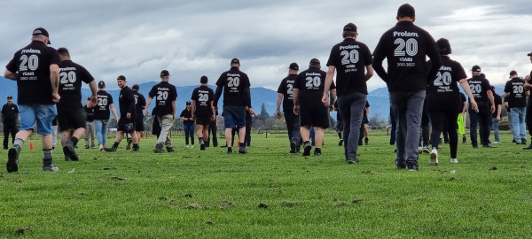 People walking on a paddock wearing shirts with a number 20 on the back